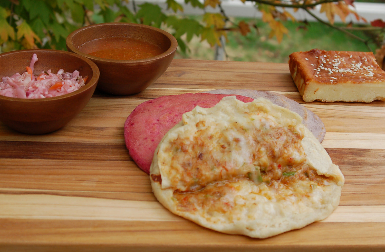 Xinca Foods dishes. Open beans and cheese pupusa, with a side of pickled cabbage and salsa. Also, a sweet quesadilla pastry.